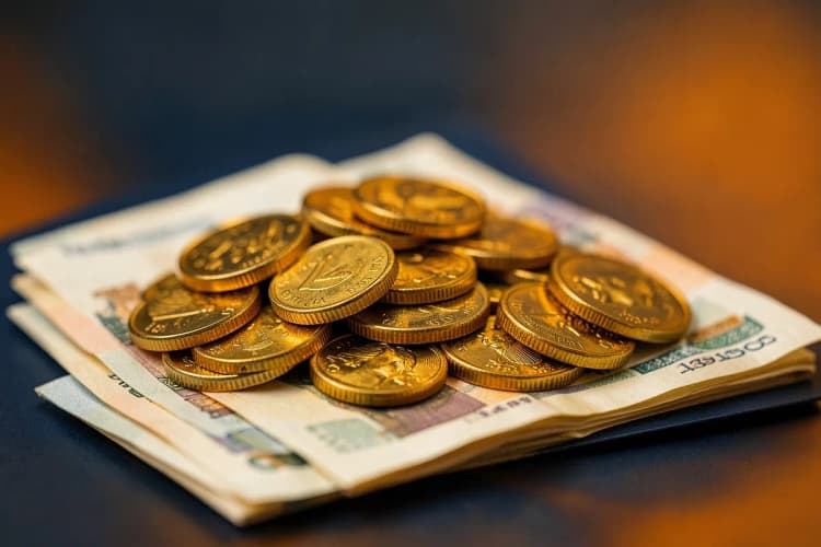 Uma pilha de moedas de ouro e notas de dinheiro.